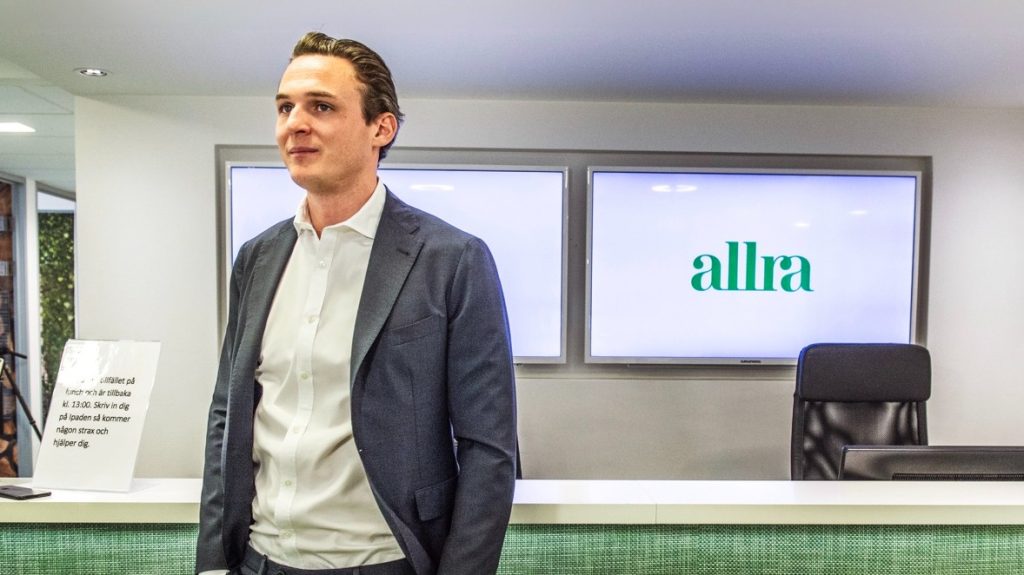 En man framför logotypen för Allra