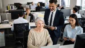 Senior kvinna i landskapsmiljö med yngre medarbetare. Foto: Grok