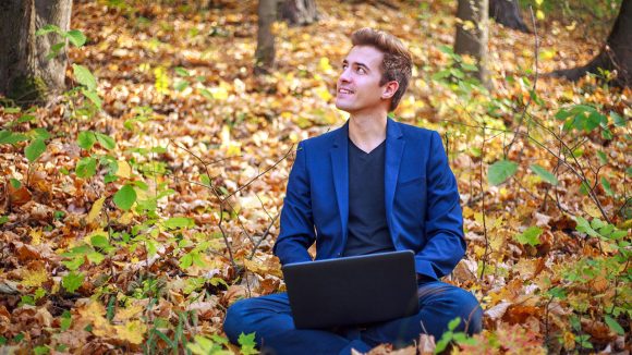 kille i kostym jobbar i naturen